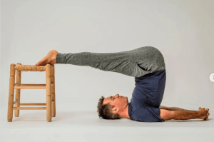 Postura del Arado en Yoga con un banco